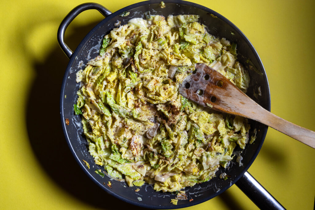 Wirsing-Zitronen-Pasta schmort in einer Pfanne.