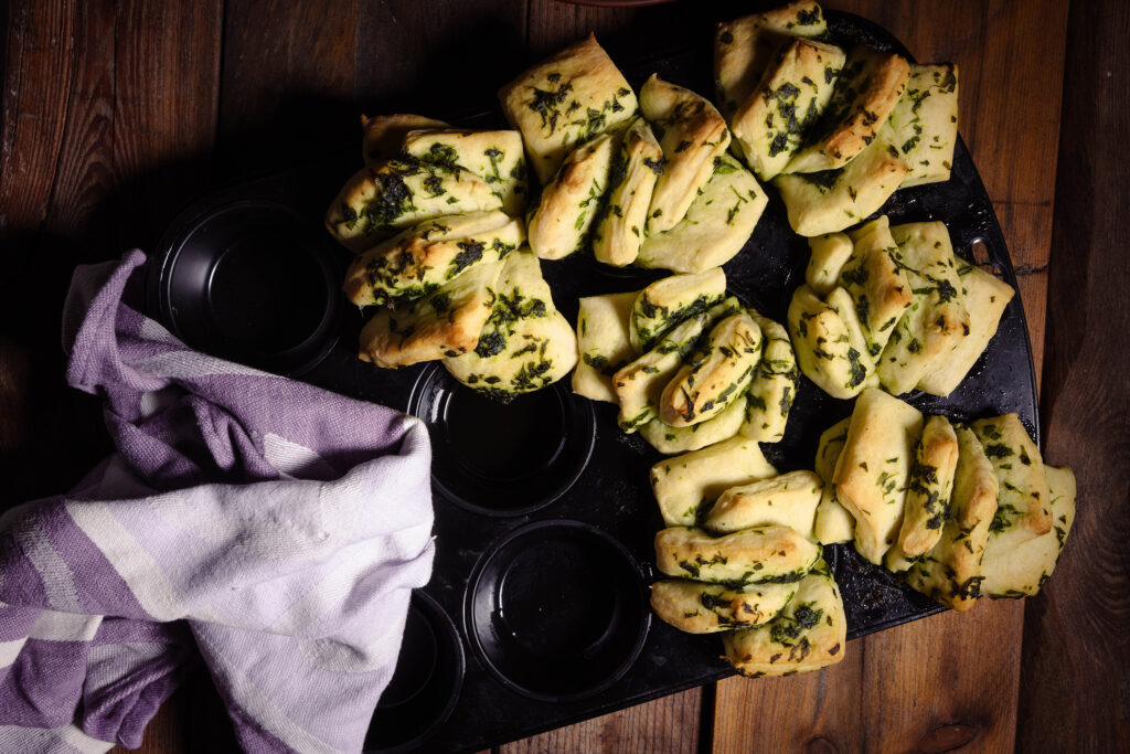 Ein Muffinblech mit frisch gebackenen Bärlauch-Zupfbroten.