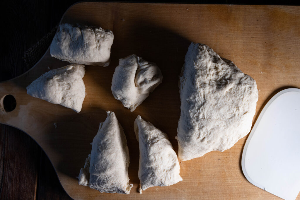 Ein aufgegangener Kefirteig wird mit einer Teigkarte geteilt.