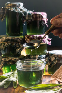 Spitzwegerich-Hustensaft in Gläsern und auf einem Löffel