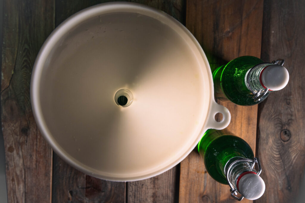 Waldmeistersirup wird in Flaschen abgefüllt.