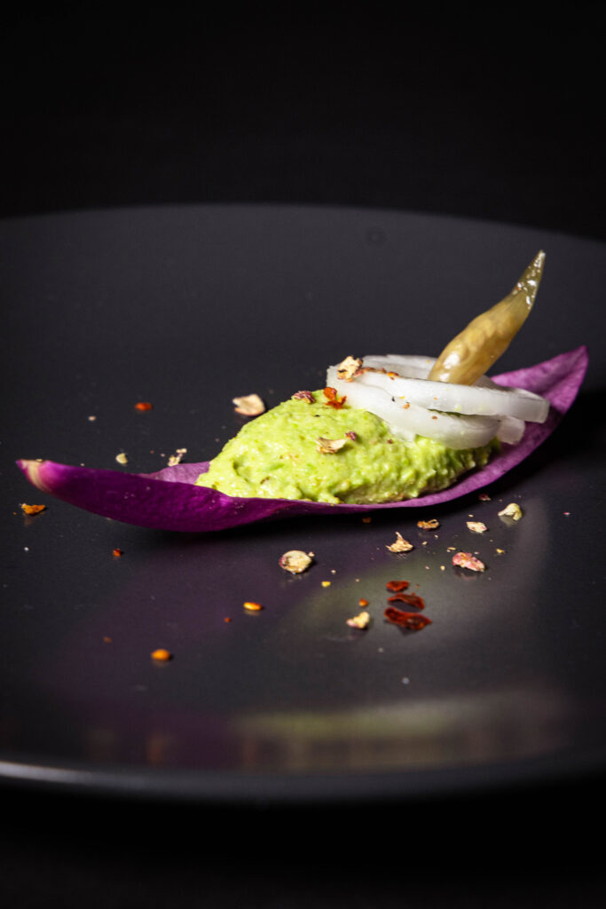 Amuse Bouche für den Frühling: Magnolienblütenblatt, Grüner Umami Dip, Mairübchen und als Krönung eine säuerliche Bärlauchkaper.