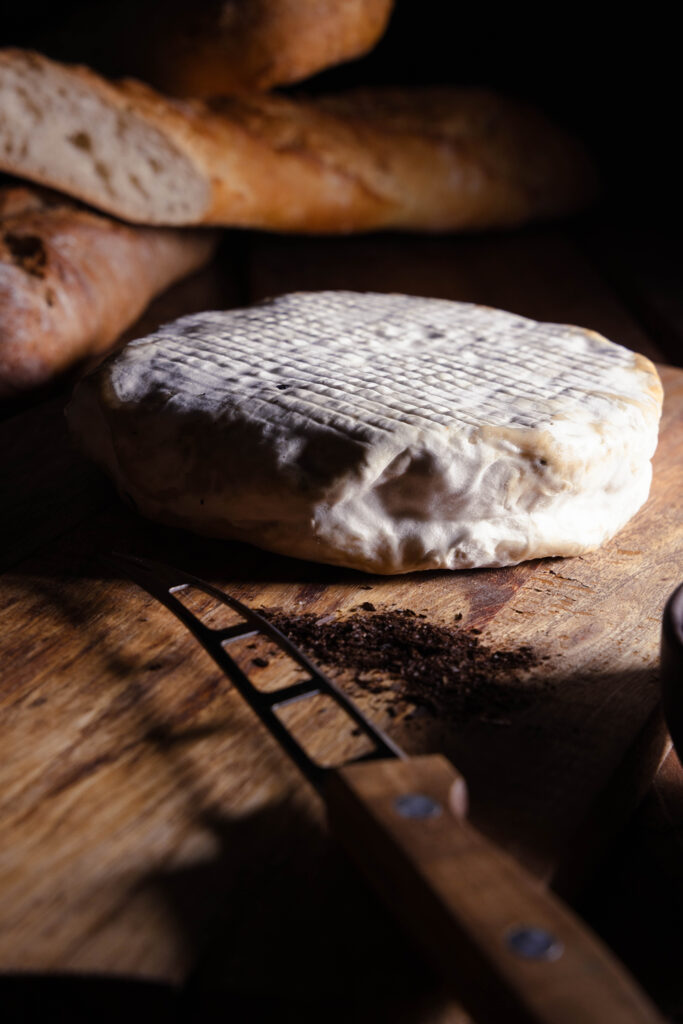 Ein veganer Brie auf einem Holzbrett.