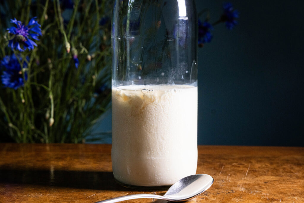 Sojamilch in einer Flasche. Die Milch stockt, da Apfelessig hinein gegeben wurde.
