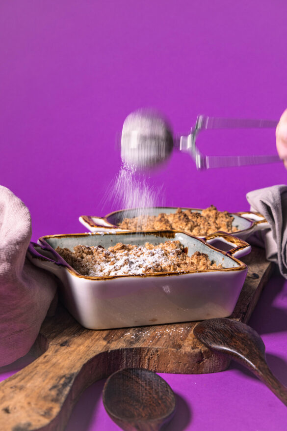 Rhabarber Crumble wird mit Puderzucker bestreut